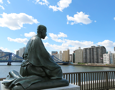 芭蕉庵史跡展望庭園（分館屋上）の芭蕉像。写真奥に見える橋は清洲橋。